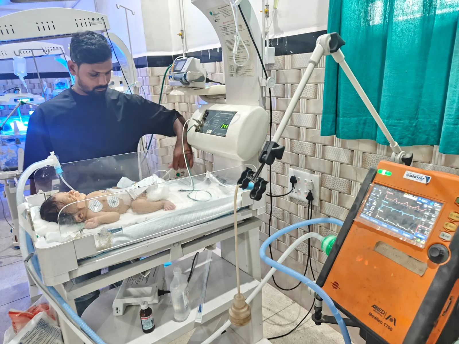 Doctor Examining Infant in NICU